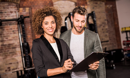 Fitnessmanagerin in einer Besprechung mit einem Mitarbeiter im Fitnessclub