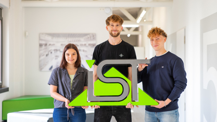 Leonie, Sebastian und Florian heben ein großes IST-Logo