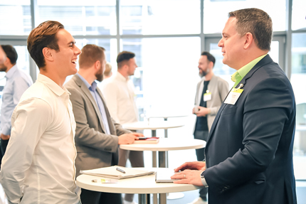 Geschäftsmänner an Stehstischen lernen sichbeim Speed-Networking in wenigen Minuten kennen