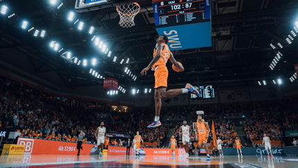 Basketballspieler springt am Korb hoch